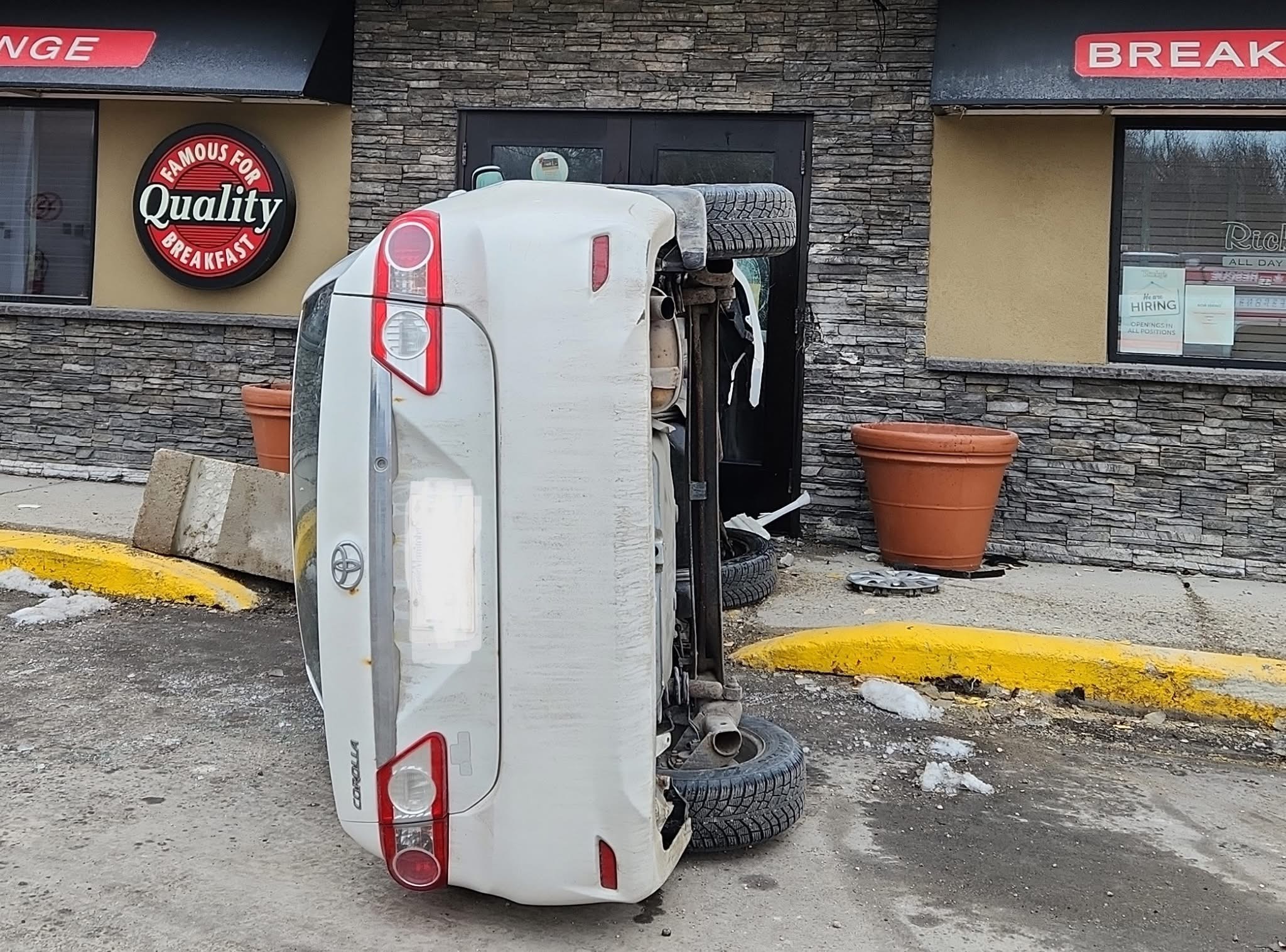 Vehicle flips into business entrance in early morning crash