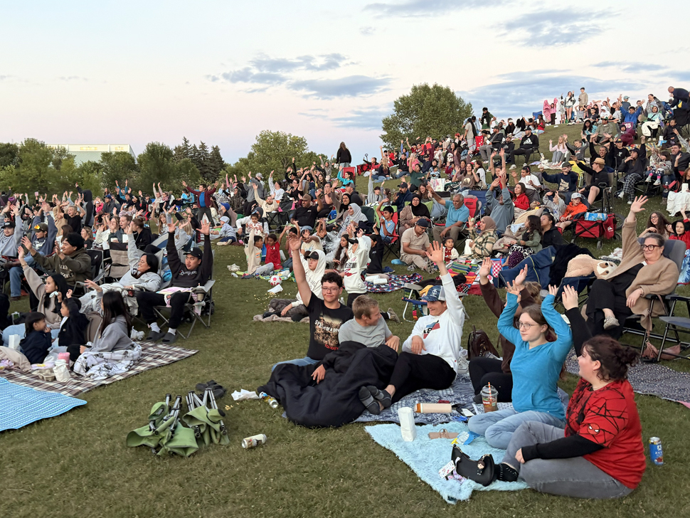 Families gather in Steinbach for outdoor movie at sunset